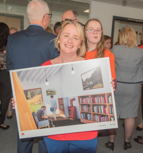 Donna Dunn holding an artist's impression of the library that will be dedicated in memory of her 'bookworm' daughter, Emily Clark