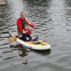 a man and boy sat on a paddleboard