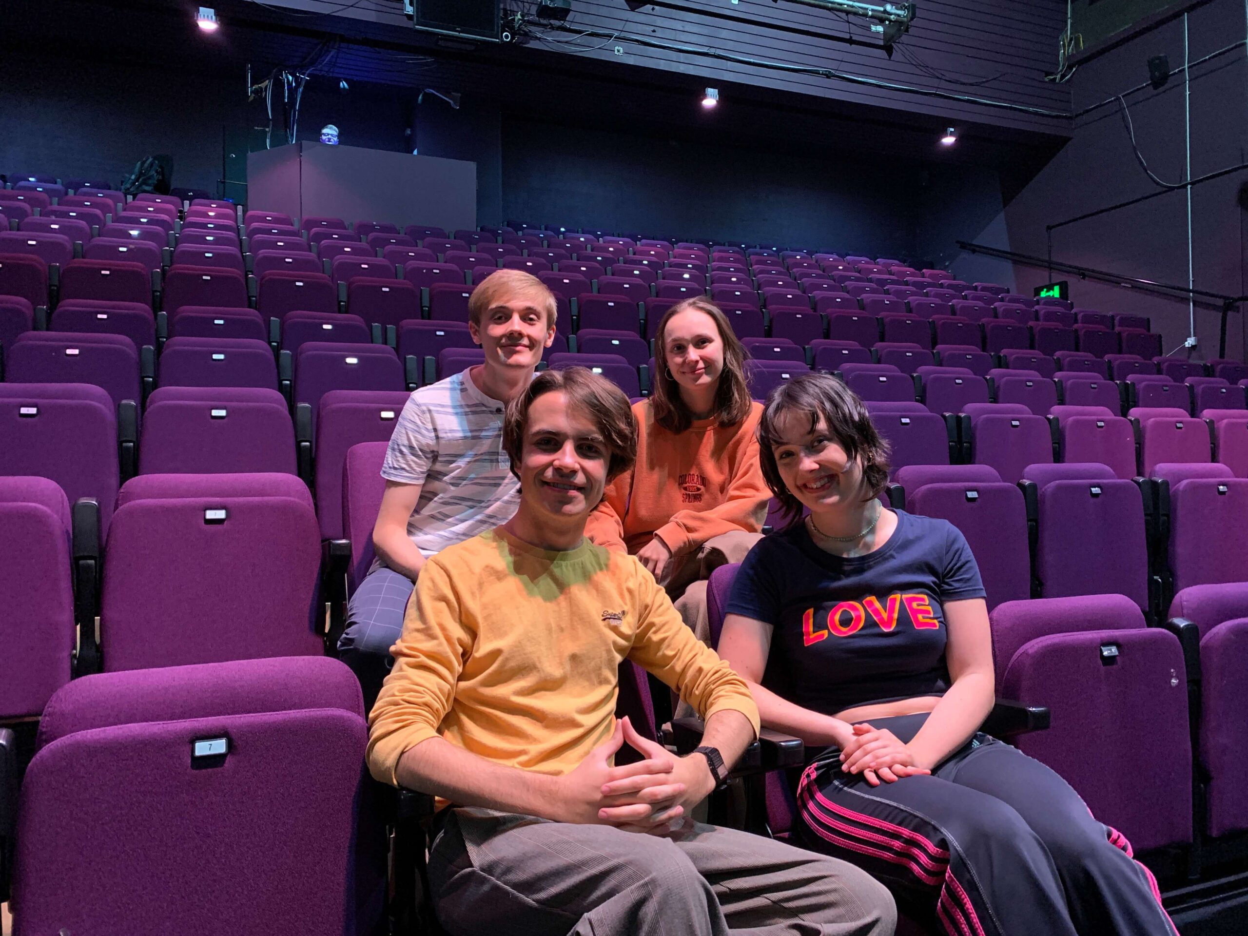 four actors sat in a theatre