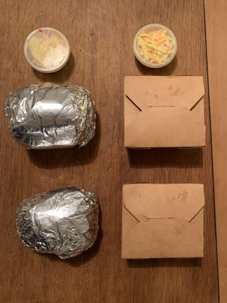 a burger wrapped in foil and chips in a box