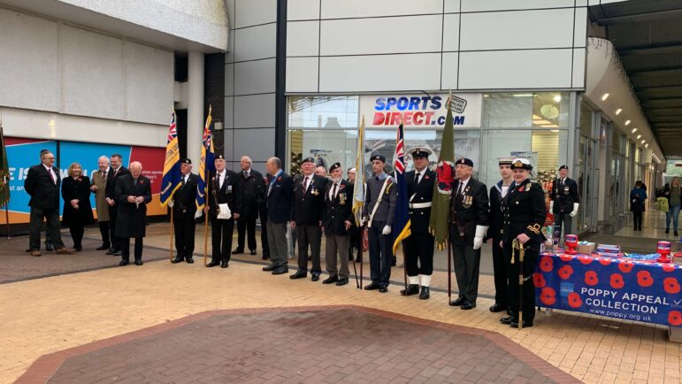 A row of people, some holding flags, at the launch of the poppy appeal