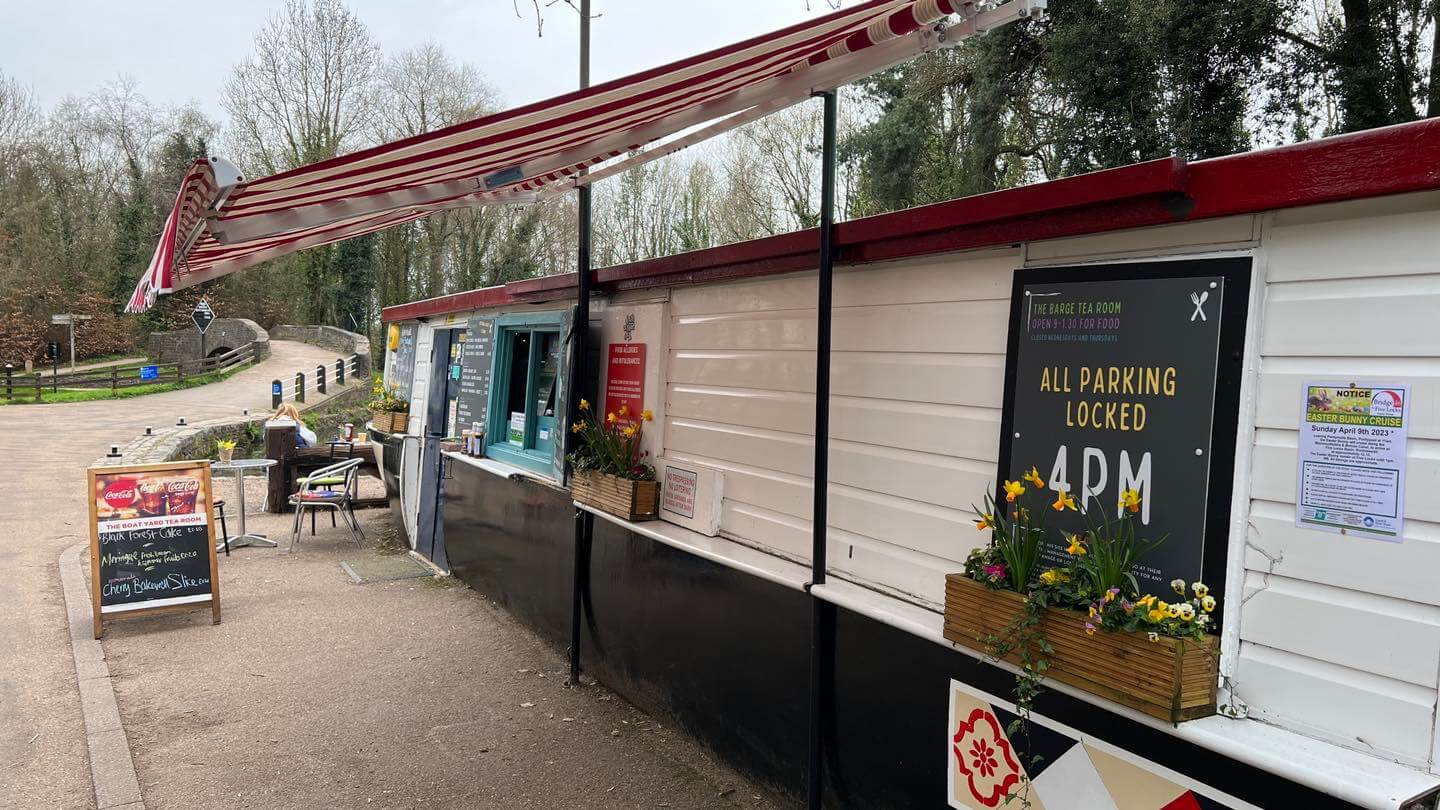 a canal barge next to a canal that serves food and drink