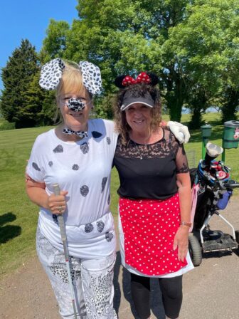 two golfers, one dressed as a Dalmatian and one dressed as minnie mouse