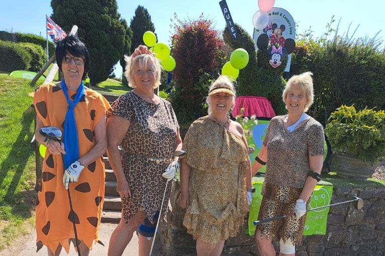four women golfers dressed as The Flintstone characters