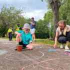 a child and mum drawing in chalk on a path