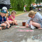 children draw in chalk on a path
