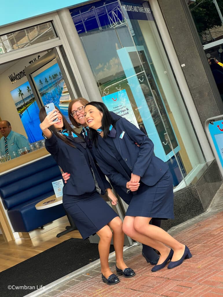 three women taking a selfie outside a travel agent