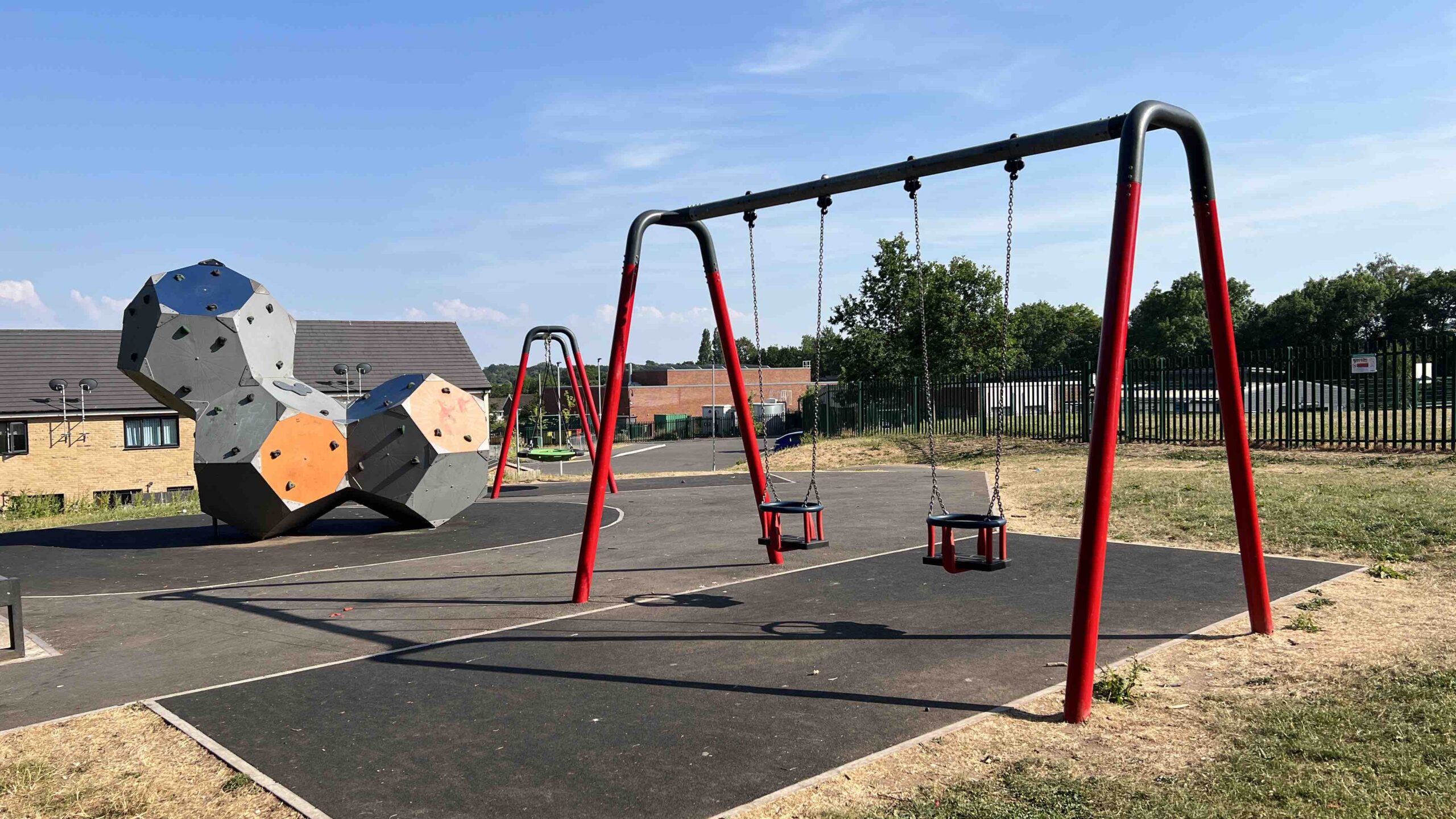 a play park including swings and large blocks to climb on