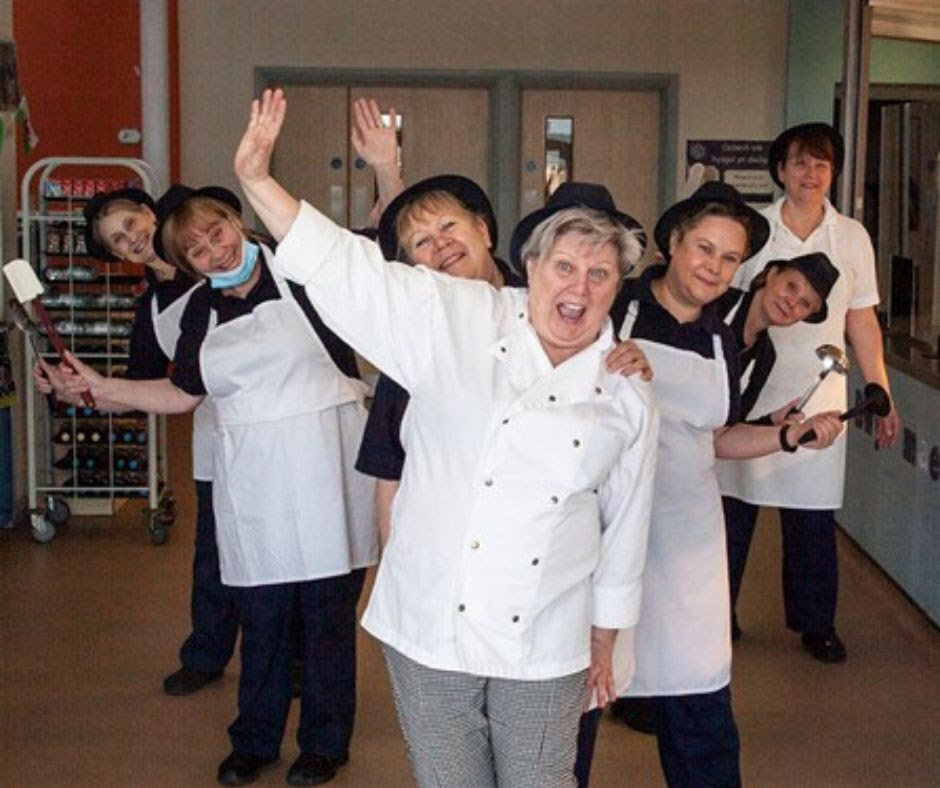 a group of woman in a school kitchen waving and celebrating being shortlisted for an award