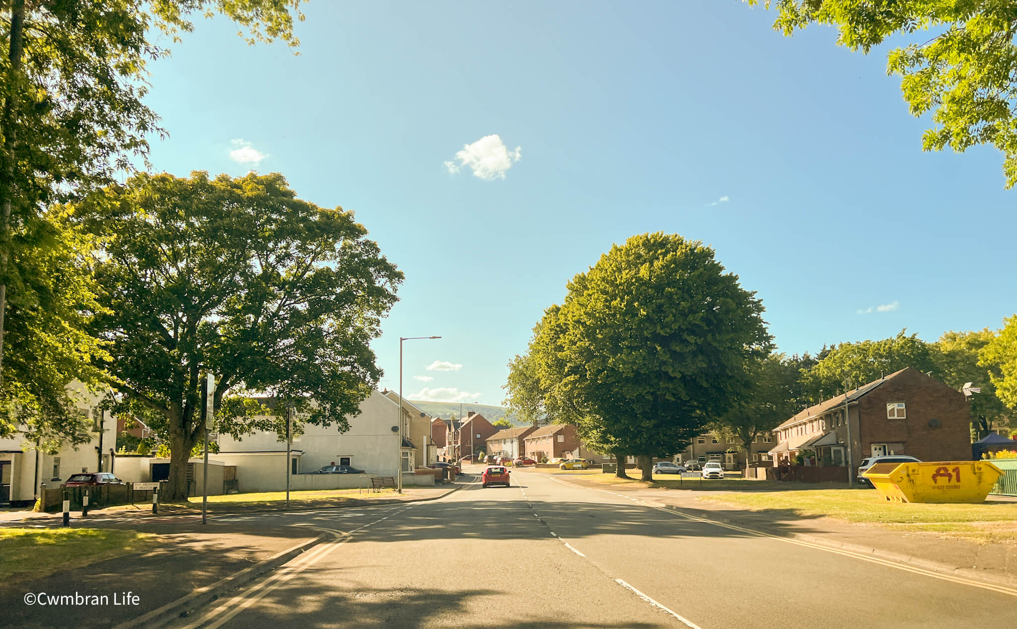Oakfield Road in Cwmbran. A street with several trees along it