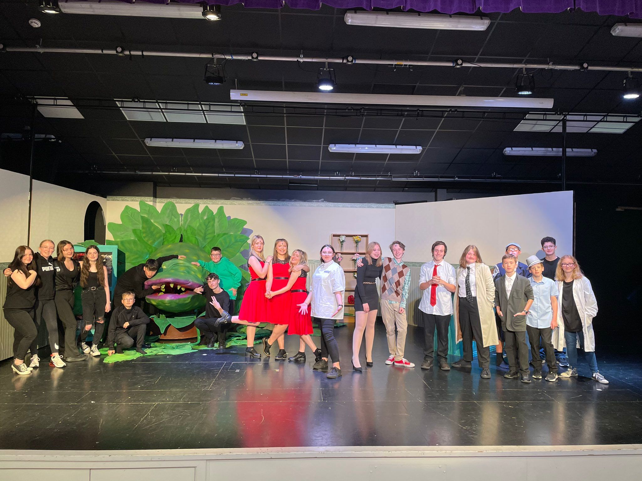 a cast of little shop of horrors on stage