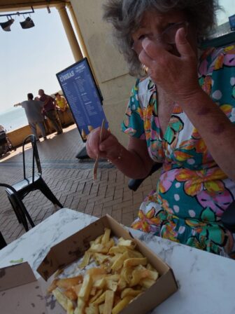 a woman eating fish and chips