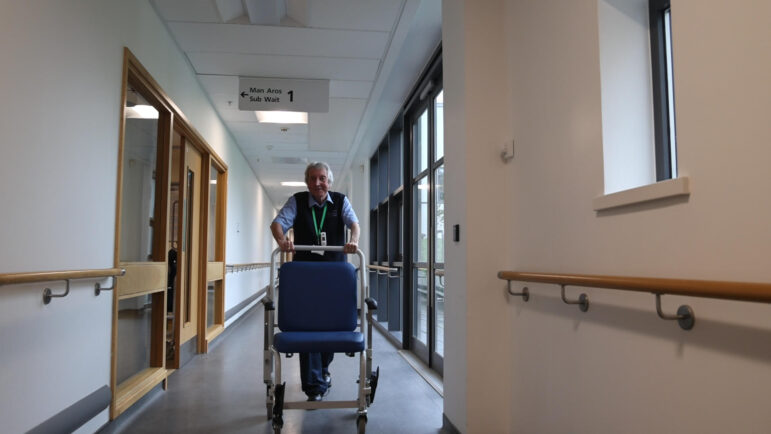 a hospital porter pushing a chair