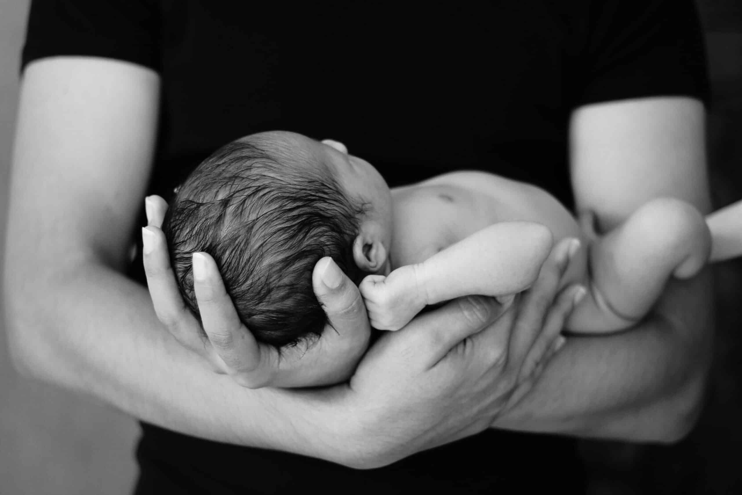 a newborn baby being held