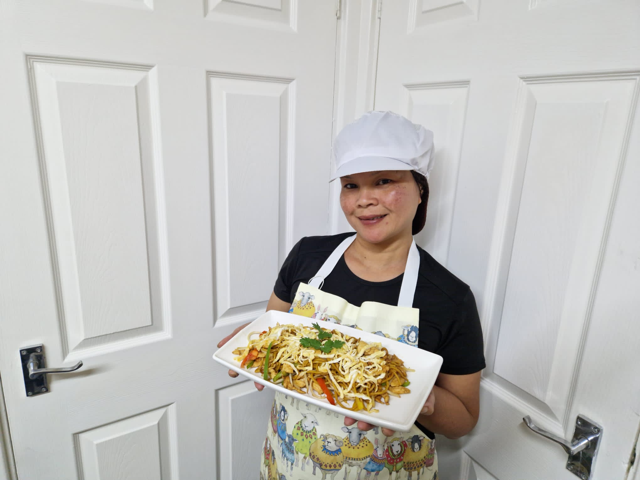 a woman holding up a thai meal