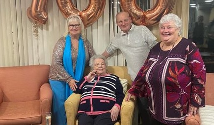 a woman celebrating her 100th birthday with familly