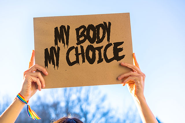 a person holds up a my body, my choice sign