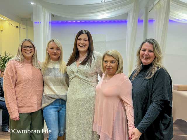 five women stood in row at beauty salon