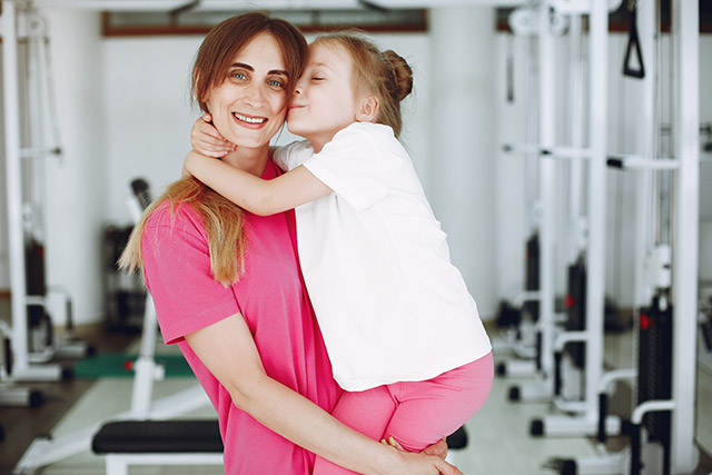 mum holding her daughter in a gym