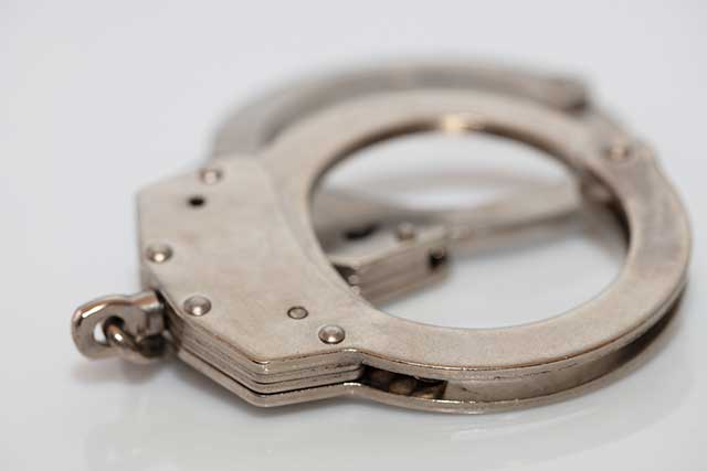 Closeup shot of a metal handcuffs on a white background
