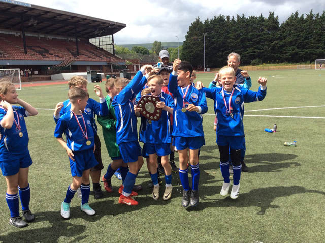 junior school football team celebrate with a trophy