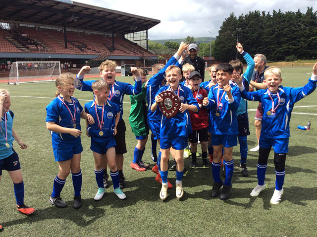 junior school football team celebrate with a trophy