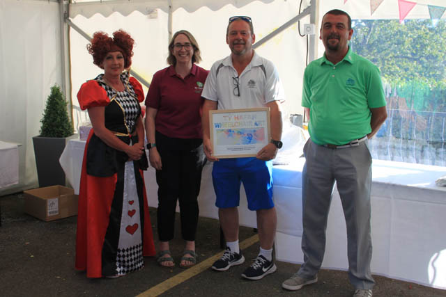 four people stood in line, one in fancy dress and one holding a certificate