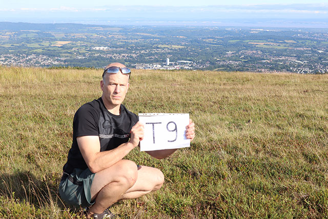 a man crouching on a hillside