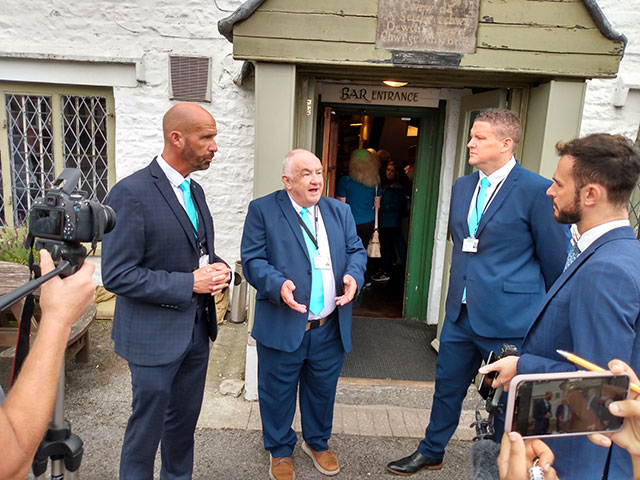 From left, new Reform UK Wales councillors David Thomas, Alan Slade and Jason O\'Connell speaking with a television reporter