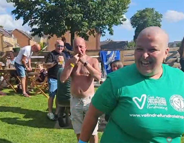 a woman moments after having her head shaved for charity smiling