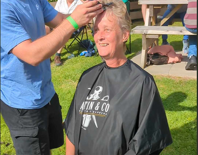 a woman having her head shaved