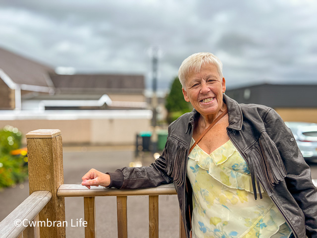 a woman leaning on wooden fence