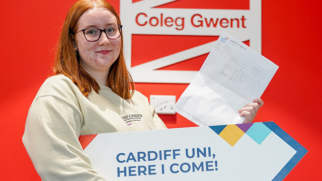 a teenager hold a sign saying 'cardiff uni here I come!'