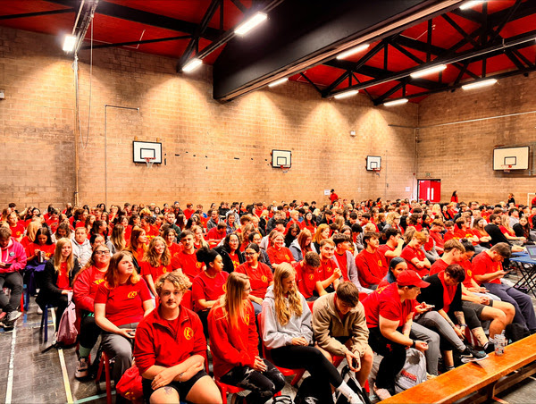 a school hall full of young people sat down in chair