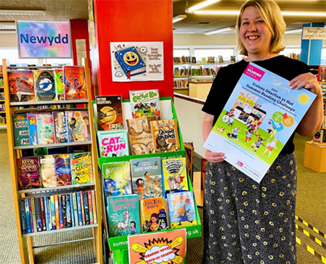 a woman holding a children's book in a library