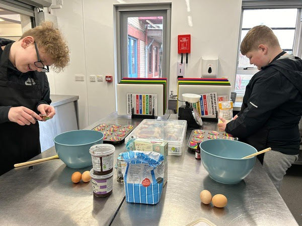 two young people cooking in kitchen