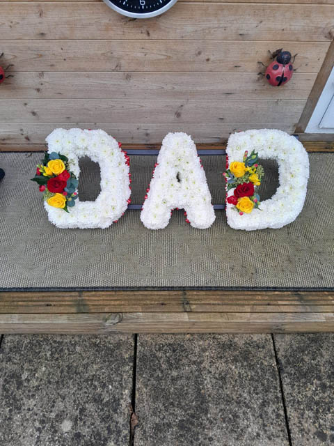 floral tributes spelling out dad