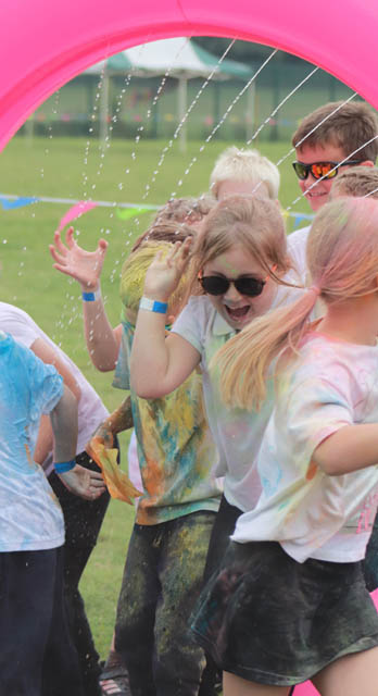 children running under water spray