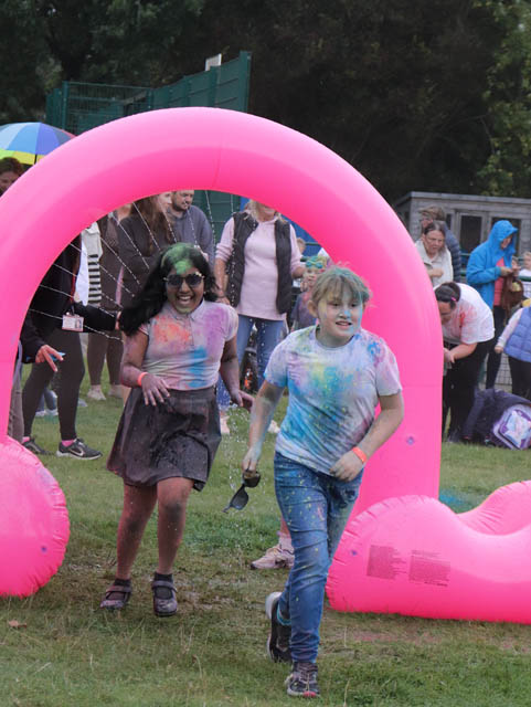 children run under a pink inflatable