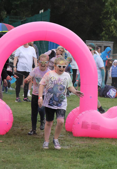 children run under a pink inflatable