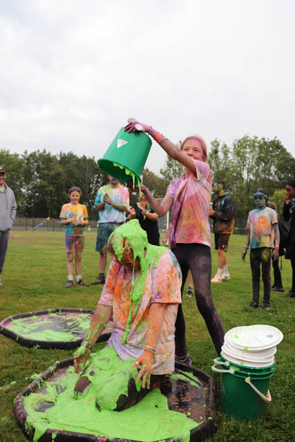 a girl pours green gunge over someone