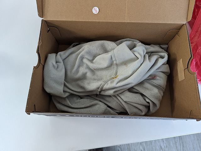 a cardboard box with a blanket inside it