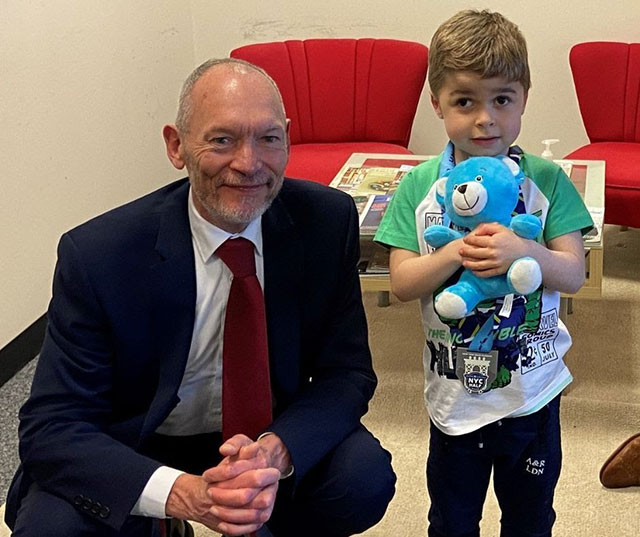 a man kneeling next to a six-year-old boy