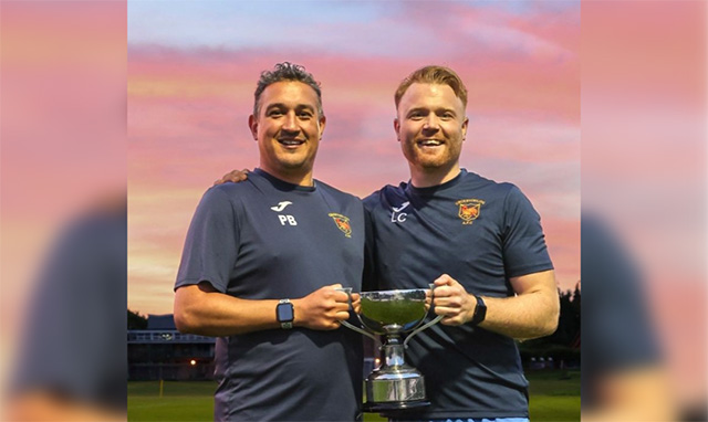 two football managers holding at trophy