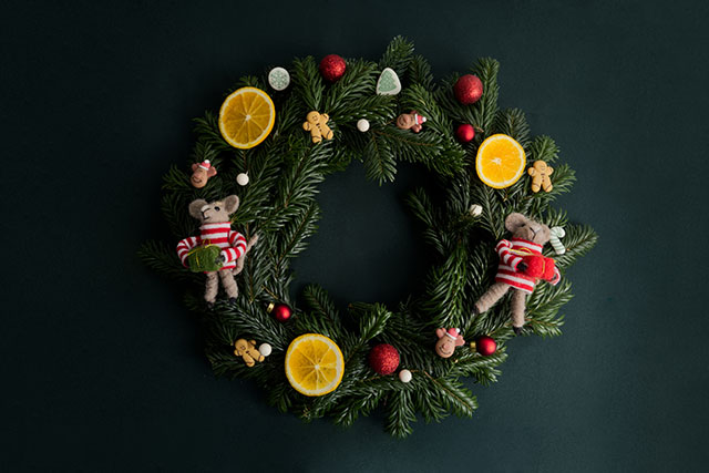 Fir wreath decorated with Christmas decor on a deep green background