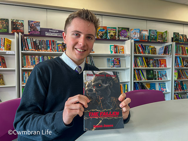 a teenage boy holds a book