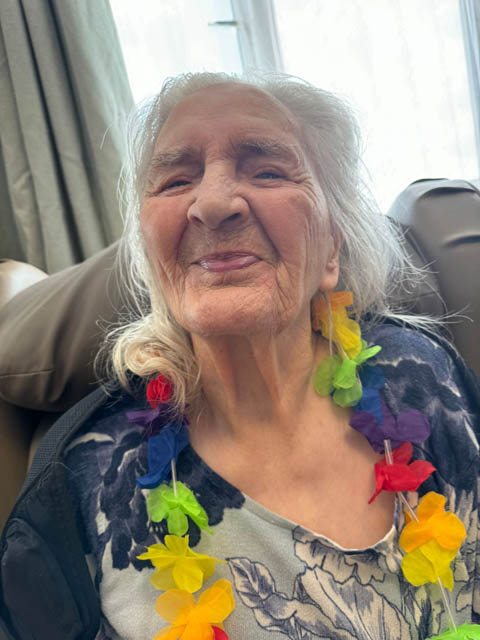 a woman with colourful flowers around her neck