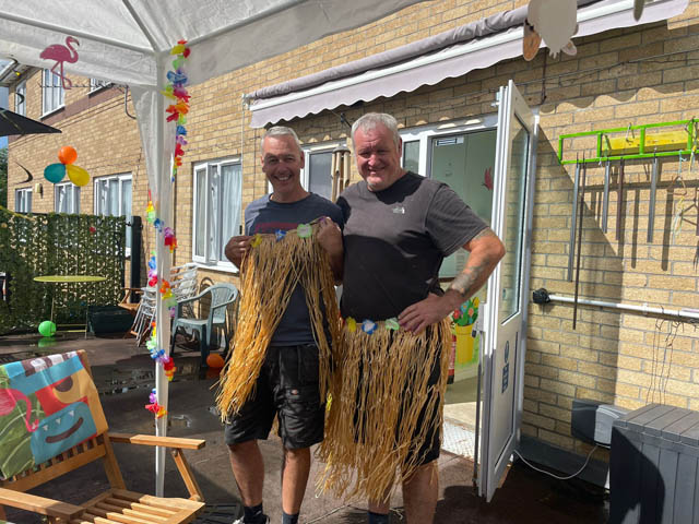 two men dressed in grass skirts