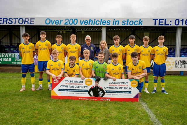 a football team have a photo on a pitch