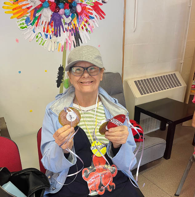 a woman holds up a medal